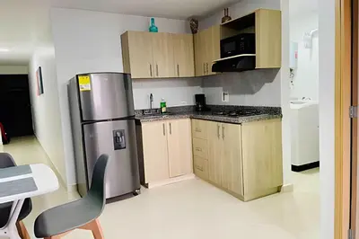 a kitchen with a stainless steel refrigerator and wooden cabinets at 9903 Vista al sur de la ciudad para 2 in Envigado