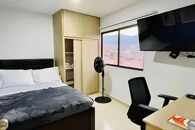 a bedroom with a bed and a desk with a computer at 9903 Vista al sur de la ciudad para 2 in Envigado