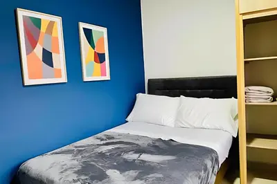 a blue bedroom with a bed and two framed art at 9903 Vista al sur de la ciudad para 2 in Envigado