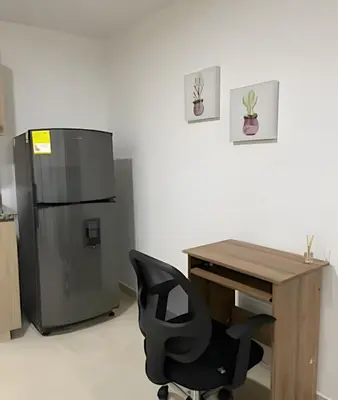 an office with a desk and a chair next to a refrigerator at 9902Aparta estudio totalmente dotado WiFi200 megas in Envigado