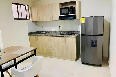 a kitchen with a stainless steel refrigerator and a table at 9902Aparta estudio totalmente dotado WiFi200 megas in Envigado