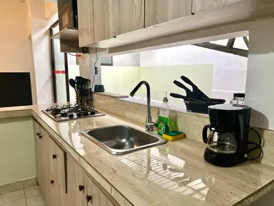 a kitchen counter with a sink and a stove at Casa Tradicional Remodelada en Envigado con Patio in Envigado