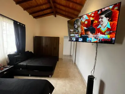 a living room with a flat screen tv on the wall at Casa Tradicional Remodelada en Envigado con Patio in Envigado