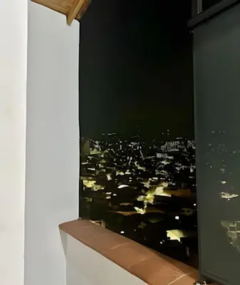 a window with a view of a city at night at beautiful view of the city with local experience in Envigado