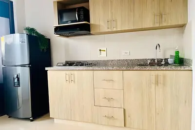 a kitchen with wooden cabinets and a stainless steel refrigerator at beautiful view of the city with local experience in Envigado