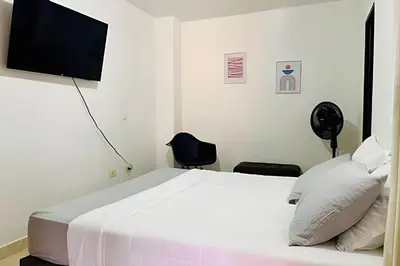 a bedroom with a bed and a flat screen tv at Duplex con terraza en el corazón de Envigado 300mb in Envigado