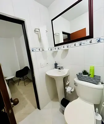 a bathroom with a toilet and a sink and a mirror at Duplex con terraza en el corazón de Envigado 300mb in Envigado