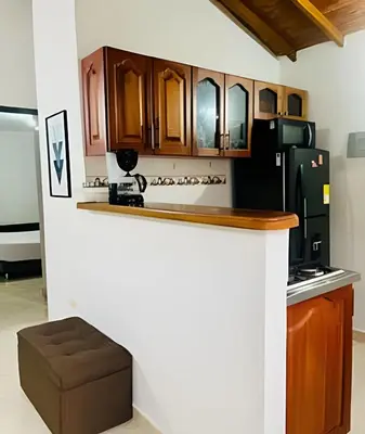a kitchen with wooden cabinets and a black refrigerator at Duplex con terraza en el corazón de Envigado 300mb in Envigado