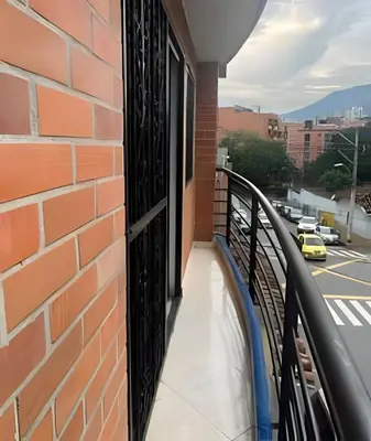 a balcony with a brick wall and a black door at Duplex con terraza en el corazón de Envigado 300mb in Envigado