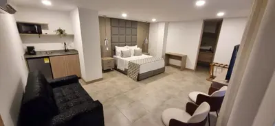 a hotel room with a bed and a kitchen at Hotel 45 Park in Sabaneta