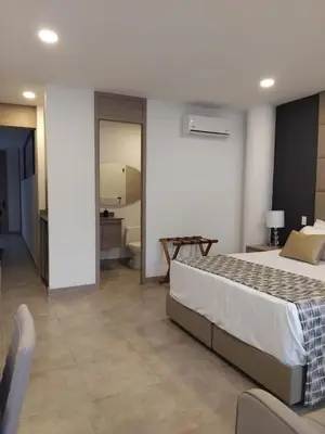 a bedroom with a large bed and a bathroom at Hotel 45 Park in Sabaneta