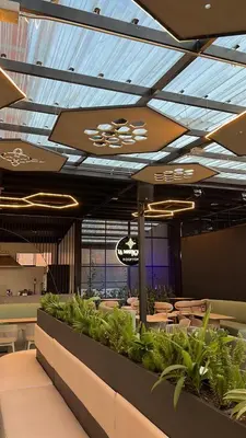 a dining room with tables and plants in a building at Hotel 45 Park in Sabaneta