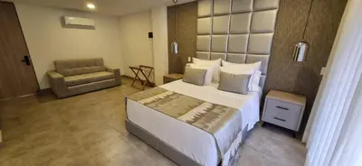 a bedroom with a large bed and a chair at Hotel 45 Park in Sabaneta
