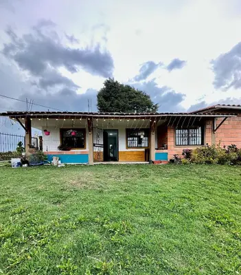 a house with a grass yard in front of it at Santaelena Cielo · Retiro natural cerca al Parque Arví Wi-Fi Starlink in Medellín
