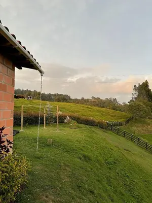 a yard with a swing in the middle of a field at Santaelena Cielo · Retiro natural cerca al Parque Arví Wi-Fi Starlink in Medellín