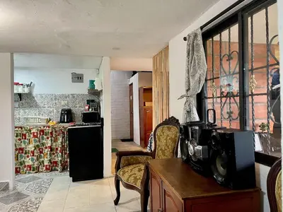 a kitchen with a table and a refrigerator in a room at Santaelena Cielo · Retiro natural cerca al Parque Arví Wi-Fi Starlink in Medellín