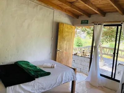 a bedroom with a bed in a room with a window at Los Lagos de Jasú in San Vicente