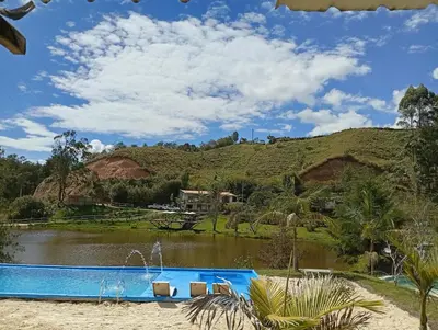 a swimming pool in front of a hill with a lake at Los Lagos de Jasú in San Vicente