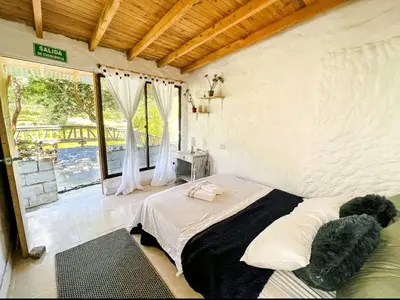a bedroom with a bed and a large window at Los Lagos de Jasú in San Vicente