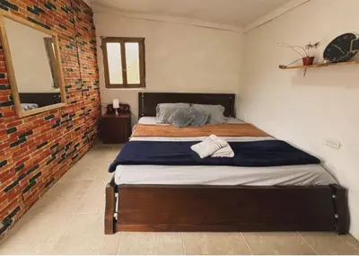 a bed in a room with a brick wall at Los Lagos de Jasú in San Vicente