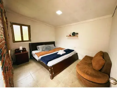 a small bedroom with a bed and a chair at Los Lagos de Jasú in San Vicente