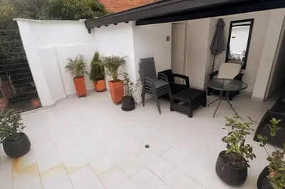 a patio with potted plants and a table and chairs at Casa de Ensueño El Poblado in Medellín