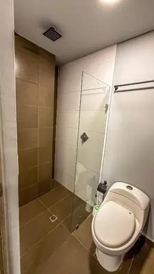 a bathroom with a toilet and a glass shower at Edificio Atalanta en el corazón de Medellín in Medellín