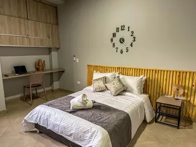 a bedroom with a bed and a clock on the wall at Edificio Atalanta en el corazón de Medellín in Medellín