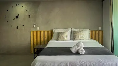 a bedroom with a large bed with a clock on the wall at Edificio Atalanta en el corazón de Medellín in Medellín
