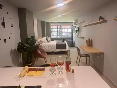 a room with a table with wine glasses and a bed at Edificio Atalanta en el corazón de Medellín in Medellín