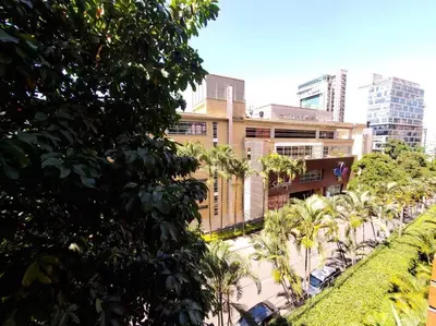 a building with palm trees in a city at Apartamento Ejecutivo El Poblado Renta Larga 28 dias Amueblado WiFi in Medellín