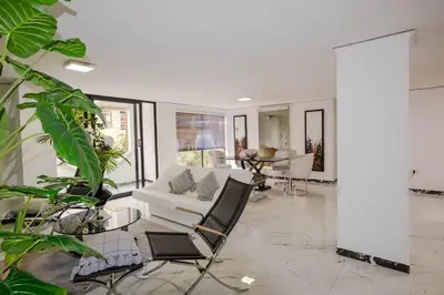 a living room with a white couch and chairs at Apartamento Ejecutivo El Poblado Renta Larga 28 dias Amueblado WiFi in Medellín