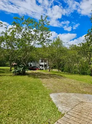 a grassy yard with a house in the background at Tranquilidad y Naturaleza Cabaña Concepción in Concepción