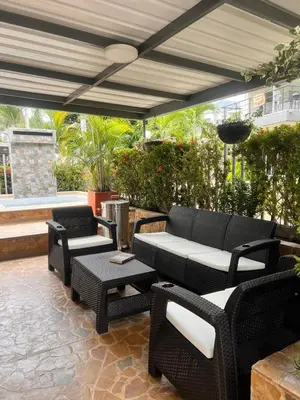 a patio with chairs and tables and a umbrella at Ciudadela Santa Fe in Santa Fe de Antioquia