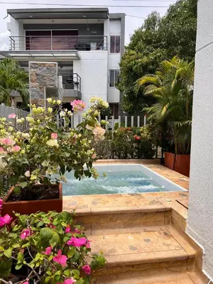 a swimming pool in front of a building with flowers at Ciudadela Santa Fe in Santa Fe de Antioquia