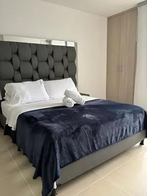 a bedroom with a large bed with a blue blanket at Moderno Apartamento en Sabaneta cerca al parque in Sabaneta