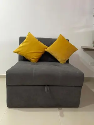 a gray couch with two yellow pillows on it at Moderno Apartamento en Sabaneta cerca al parque in Sabaneta