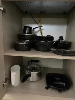a kitchen shelf with pots and pans and a phone at Moderno Apartamento en Sabaneta cerca al parque in Sabaneta