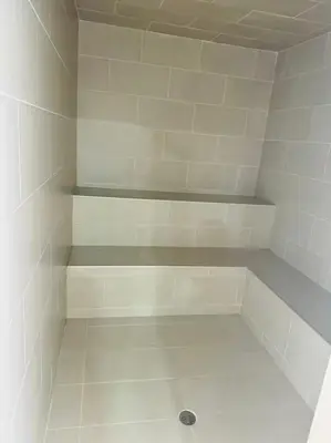 a white tiled walk in shower with shelves at Moderno Apartamento en Sabaneta cerca al parque in Sabaneta