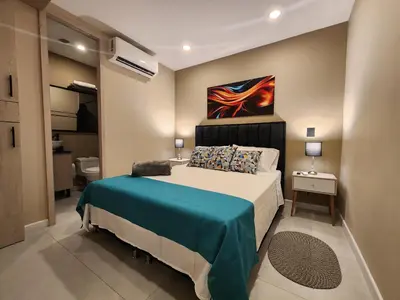 a bedroom with a bed and a painting on the wall at Loft 10, Comodo Aparta estudio 201 in Medellín