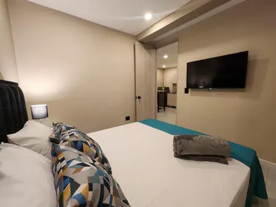 a bedroom with a bed with a flat screen tv on the wall at Loft 10, Comodo Aparta estudio 201 in Medellín