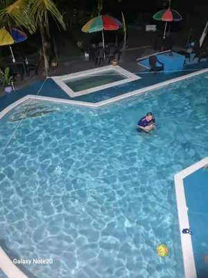 a person swimming in a large swimming pool at Hermoso Duplex campestre in Honda