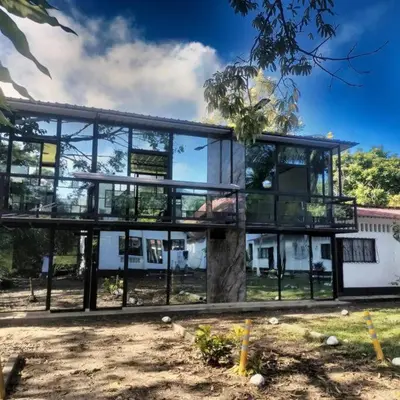 a large glass building with a tree in front of it at Hermoso Duplex campestre in Honda