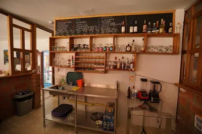 a restaurant with a counter and a menu on the wall at La Oculta Hostal in Jericó