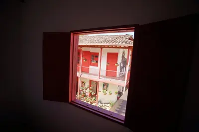 a window view of a house with a balcony at La Oculta Hostal in Jericó