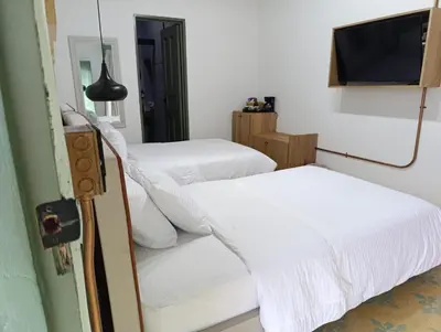 a bedroom with two beds and a tv on a wall at Hotel Nuss in San Roque