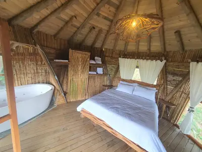 a bedroom with a bed and a tub and a chandelier at Hotel Nuss in San Roque