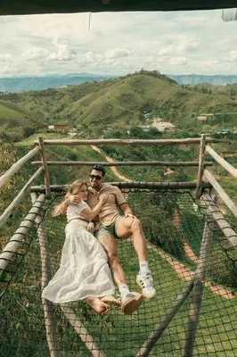 a man and a woman sitting on top of a fence at Hotel Nuss in San Roque