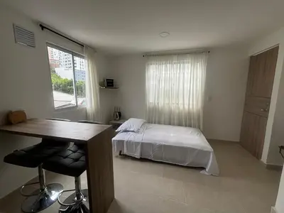 a bedroom with a bed and a desk and a window at Apartamento acogedor cerca al Cable in Manizales