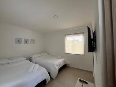 a hotel room with two beds and a window at Apartamento acogedor cerca al Cable in Manizales